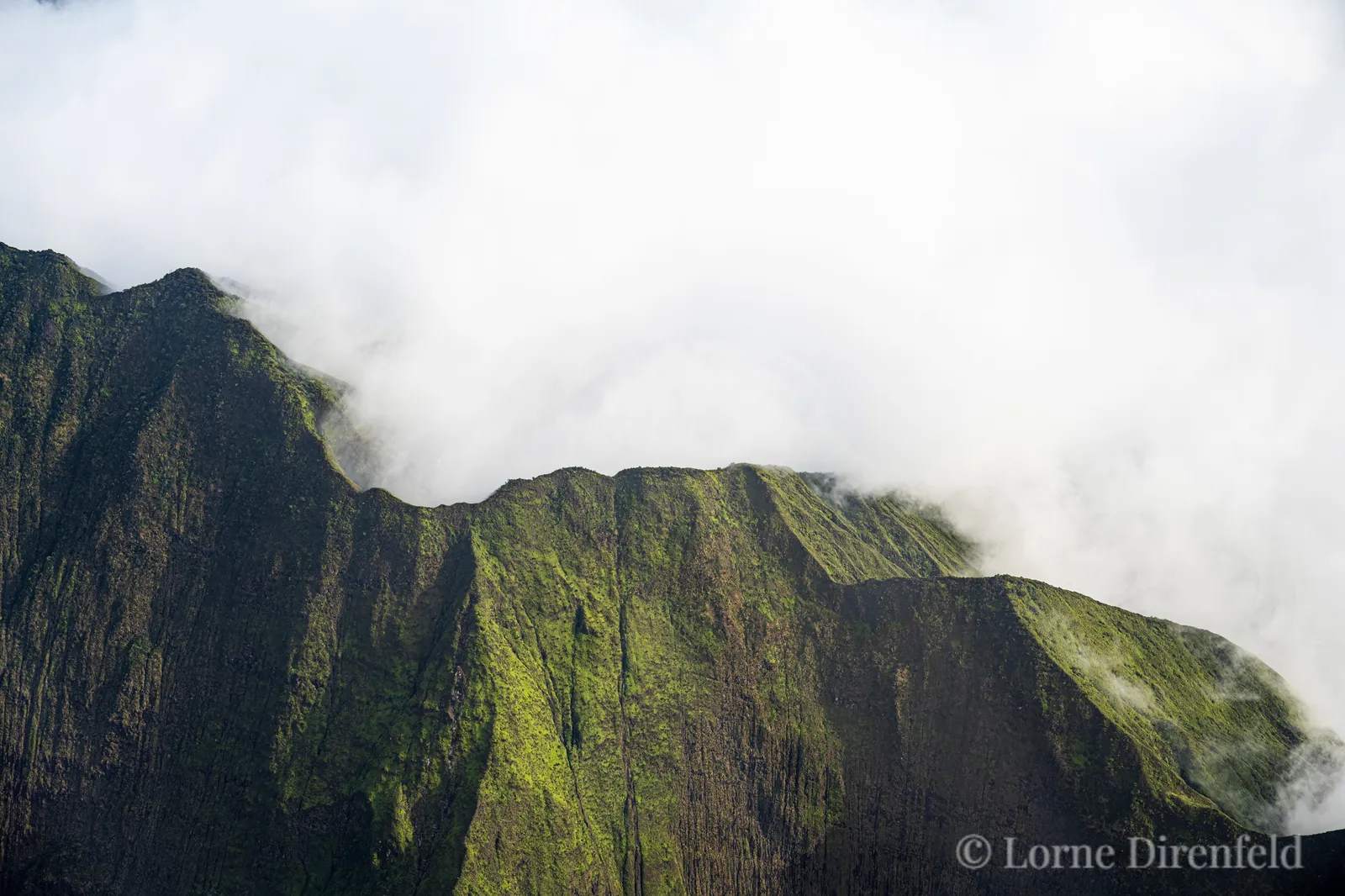 The lush green crests of west Maui mountains, filled with clouds . . .