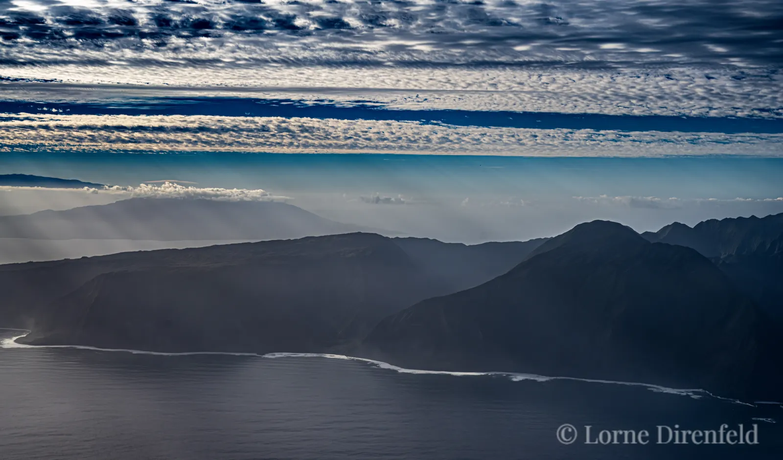 Molokai, north shore, tall sea cliffs in the early morning, with Maui in the background, upper left . . .